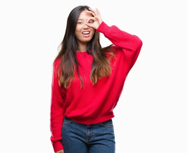 手の笑顔 幸せそうな顔で指を通して見る目で のジェスチャーを行う分離の背景に冬のセーターを着た若いアジア女性 — ストック写真
