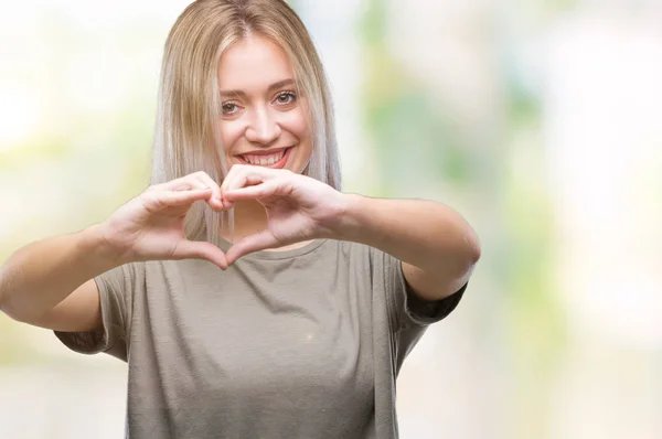 年轻的金发女人在孤独的背景下微笑着 用手展示着心的象征和形状 浪漫理念 — 图库照片