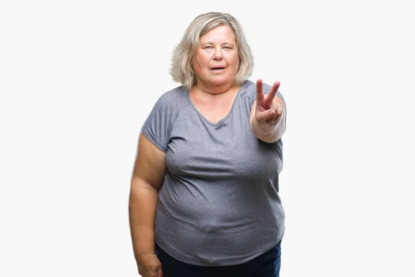 シニア プラス サイズ以上の白人女性が勝利のサインをやって指を表示するカメラを背景を笑顔を分離します — ストック写真