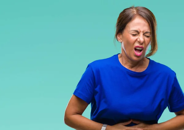 Middle age senior hispanic woman over isolated background with hand on stomach because indigestion, painful illness feeling unwell. Ache concept.