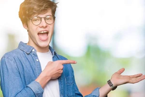 Joven Hombre Guapo Con Gafas Sobre Fondo Aislado Sorprendido Sonriendo —  Fotos de Stock