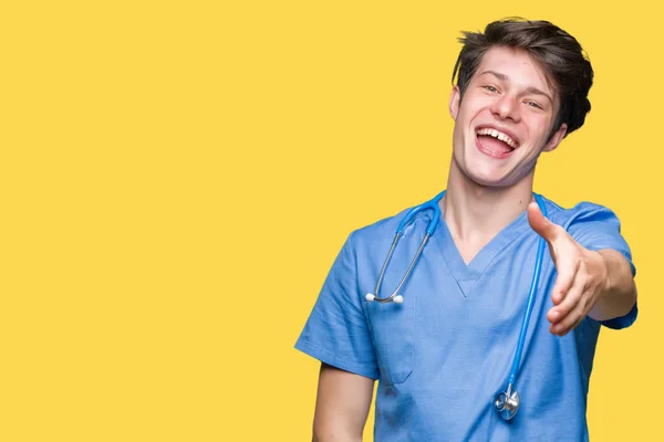 Jovem Médico Vestindo Uniforme Médico Sobre Fundo Isolado Sorrindo Amigável — Fotografia de Stock