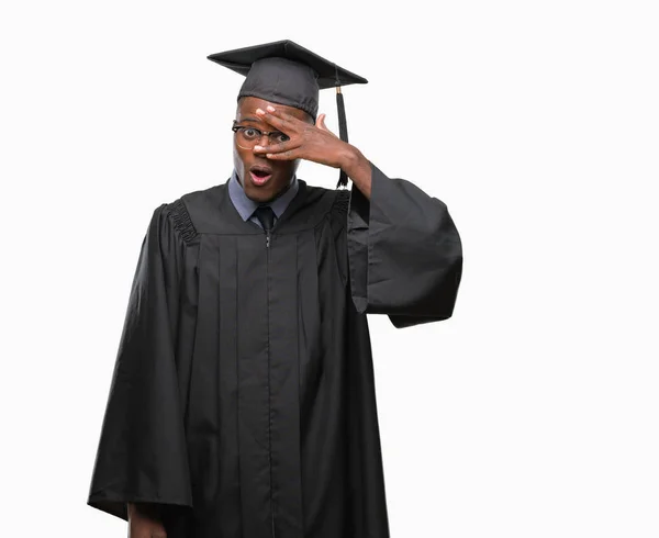 若者は顔と手で目を覆うショックでピーク分離の背景にアフリカ系アメリカ人を卒業し 恥ずかしそうな顔で指を通して見る — ストック写真