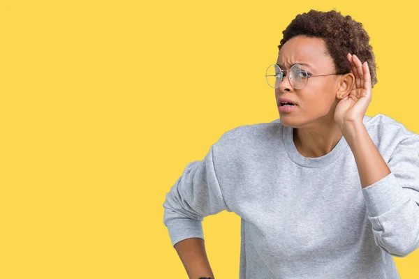 若い美しいアフリカ系アメリカ人女性の噂やゴシップに審理をリスニングの耳に手を浮かべて隔離された背景にメガネを着用します 難聴の概念 — ストック写真