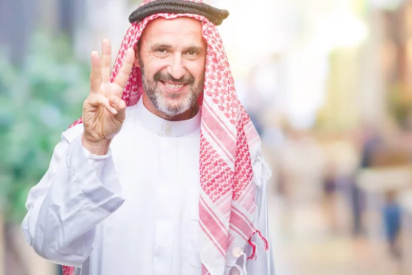シニアのアラブ人にクーフィーヤを着て分離を示す背景と自信を持って 幸せな笑みを浮かべて中 位指で上向き — ストック写真