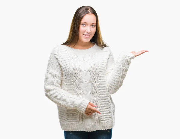 年轻美丽的高加索妇女穿着冬季毛衣在孤立的背景微笑欢快的呈现和手掌看着镜头 — 图库照片