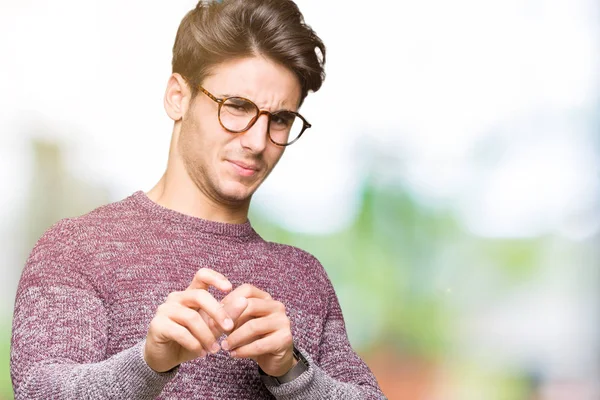 Young handsome man wearing glasses over isolated background disgusted expression, displeased and fearful doing disgust face because aversion reaction. With hands raised. Annoying concept.