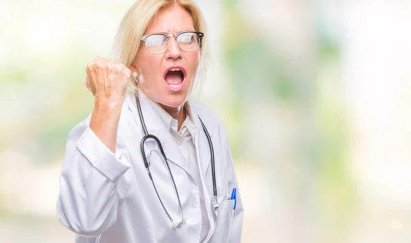 怒ってい イライラして怒りで叫びながら激怒の拳を上げる狂牛病分離の背景に中年の金髪医師女性 怒りと攻撃的な概念 — ストック写真