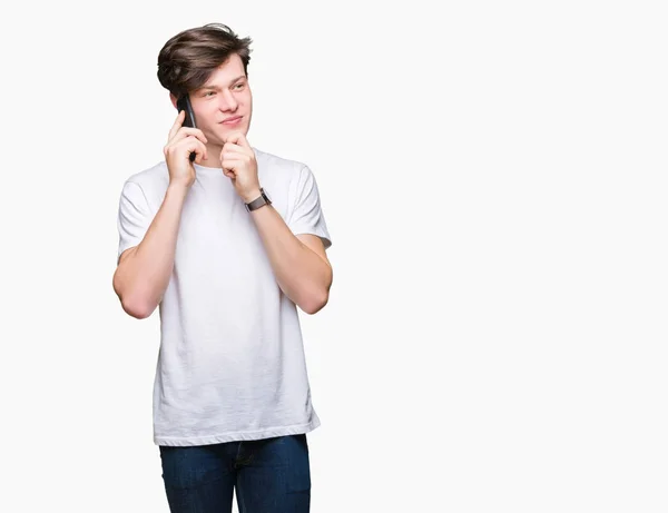 Młody Człowiek Gadasz Smartfon Nad Myślenia Białym Tle Poważne Twarz — Zdjęcie stockowe