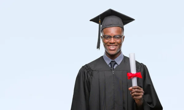 若者が立っていると自信を持って歯を見せて笑顔で笑っている幸せそうな顔で孤立の背景の上の学位を保持するアフリカ系アメリカ人を卒業 — ストック写真