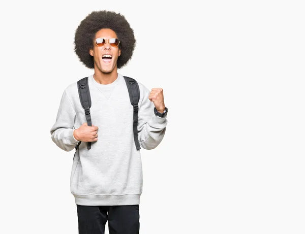 非洲青年美国男子戴着太阳镜和背包 尖叫骄傲 庆祝胜利和成功非常兴奋 欢呼的情感 — 图库照片