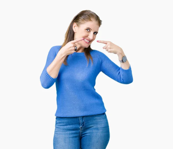 美丽的中年成熟的女人穿着冬季毛衣在孤立的背景微笑自信显示和指向用手指的牙齿和嘴 健康理念 — 图库照片
