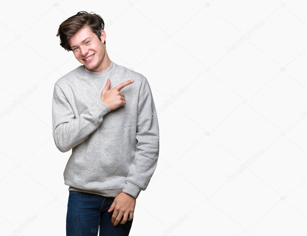 Young handsome sporty man wearing sweatshirt over isolated background cheerful with a smile of face pointing with hand and finger up to the side with happy and natural expression on face