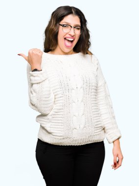 Seyir ve başparmak yanında yukarıyı mutlu yüz ile gülümseyen gözlüklü genç güzel kadın.