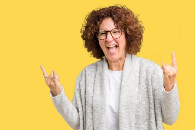 Güzel orta ager üst düzey kadın deli ifade rock simge elle yapıyor ile bağırarak izole arka plan üzerinde ceket ve gözlük takıyor. Müzik yıldızı. Ağır kavramı.