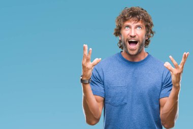 Yakışıklı İspanyol modeli adam izole arka plan çılgın ve kızgın bağırarak ve agresif ifade ve silah kaldırdı bağırıyor. Hayal kırıklığı kavramı.