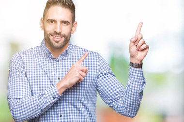 Yakışıklı delikanlı gülümseyen ve iki elleri ve parmakları ile tarafına işaret kamera bakarak izole arka plan üzerinde.