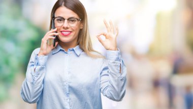 Genç güzel iş kadın konuşma arama Smartphone parmak, mükemmel sembolü ile ok işareti yapıyor izole arka plan üzerinde kullanma