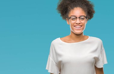 Yüzünde mutlu ve güzel bir gülümseme ile izole arka plan üzerinde gözlük takan genç afro Amerikalı kadın. Şanslı kişi.