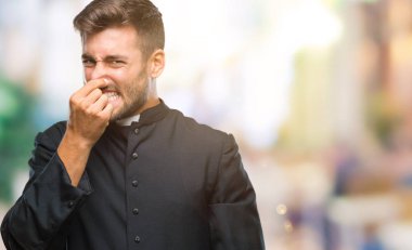 Bir şey pis ve iğrenç kokulu izole arka plan, dayanılmaz koku, holding nefes burun parmaklar ile genç Katolik Hıristiyan rahip adam. Kötü kokuyor kavramı.