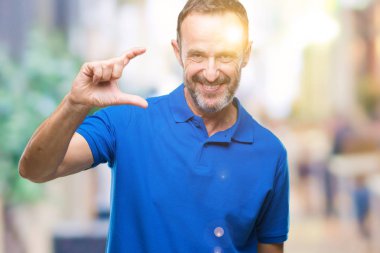Orta yaş üzerinde gülümseyen izole arka plan ve süre seyir ve kamera boyutu işaret parmaklarıyla yapıyor el ile kendine güvenen el hareketi ağarmış komuta sizde. Ölçü kavramı.