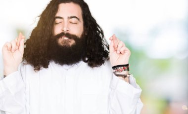 İsa Mesih giyen adam gülümseyen geçiş parmakları ile umut ve gözleri kapalı kostüm. Şans ve batıl kavramı.