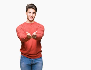 Yakışıklı delikanlı izole arka plan üzerinde gülen ellerle birlikte alma veya jest vererek palms. Ayrı tutma ve koruma