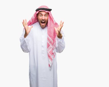 Keffiyeh üzerinde giyen genç yakışıklı adam deli kutluyor arka plan izole ve silah ile başarı için yükseltilmiş ve açık gözleri heyecanlı çığlık hayrete düşürdü. Kazanan kavramı