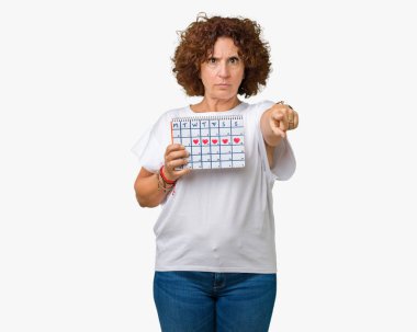 Adet takvim tutan orta ager üst düzey kadın kamera ve size parmak ile işaret arka plan izole, el işareti, pozitif ve kendinden emin bir jest ön