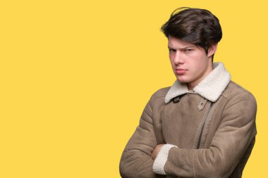 Genç yakışıklı giyen kış ceket izole arka plan şüpheci ve sinir, onaylamayan ifade yüz çapraz kolları olan adam. Negatif kişi.