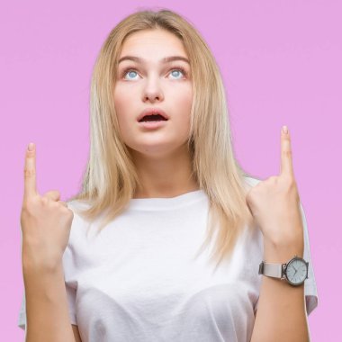 İzole arka plan üzerinde beyaz kadın hayrete ve yukarıya bakıp parmakları ile işaret şaşırttı ve silah kaldırdı.