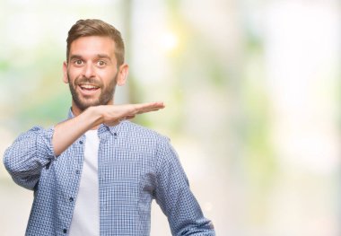 Büyük ve büyük boy işaret, ölçü birimi sembol gösteren ellerle eller izole arka plan üzerinde beyaz t-shirt giyen genç yakışıklı adam. Kameraya bakarak gülümsüyordu. Ölçüm kavramı.