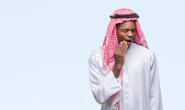 Diş ağrısı veya dişlerde dişlerle ilgili hastalık nedeniyle ağız acı ifadesi ile el ile dokunmak izole arka plan üzerinde geleneksel keffiyeh giyen genç Arapça Afrika adam. Diş hekimi kavramı.