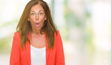 Güzel orta yaş iş yetişkin kadın izole arka plan korkuyor ve sürpriz ifade ile şok yüzünden korku ve yüz heyecanlı.