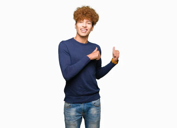 アフロ髪若いハンサムな男性自信の笑みを浮かべて手と親指 裏側を指す — ストック写真
