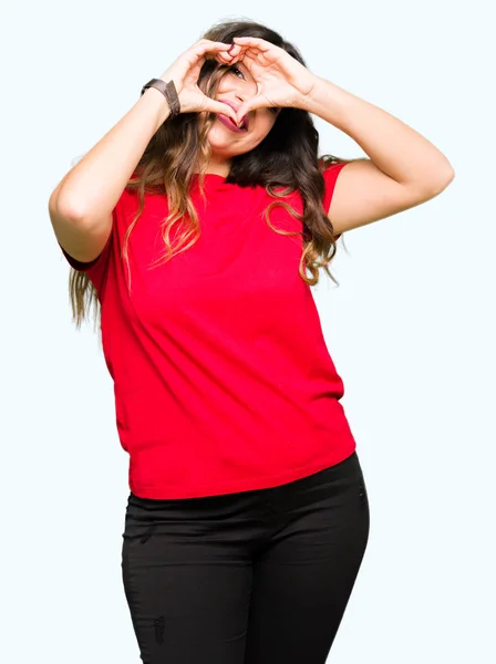 Młoda Kobieta Piękna Noszenie Shirt Dorywczo Robiąc Kształt Serca Dłoni — Zdjęcie stockowe