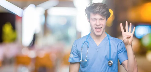 孤立した背景表示と指で上向きに医療制服を着て若い医師数は自信を持って 幸せな笑みを浮かべている間 — ストック写真