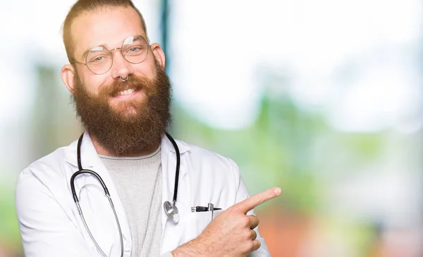 Νέοι Ξανθιά Γιατρός Άντρας Γένια Φορώντας Ιατρική Παλτό Κατάδειξης Δάχτυλο — Φωτογραφία Αρχείου