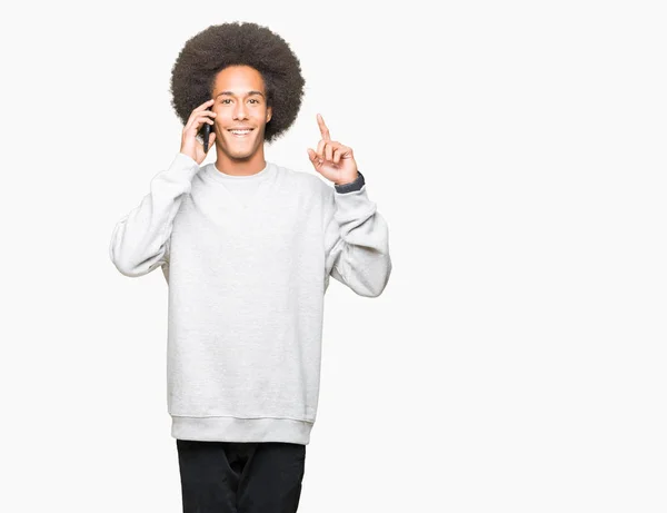 非洲青年美国人 非洲头发在智能手机上说话惊讶的想法或问题指向手指与幸福的脸 — 图库照片