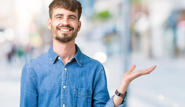 Jovem Homem Bonito Sobre Fundo Isolado Sorrindo Alegre Apresentando Apontando — Fotografia de Stock