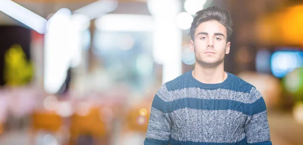 Young handsome man over isolated background Relaxed with serious expression on face. Simple and natural looking at the camera.