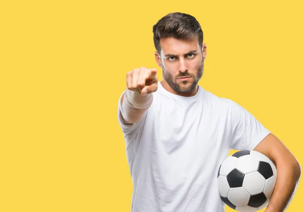 若いハンサムな男サッカー サッカー ボールを保持している分離カメラと指で指している背景 手署名 正面からポジティブで自信のジェスチャー — ストック写真