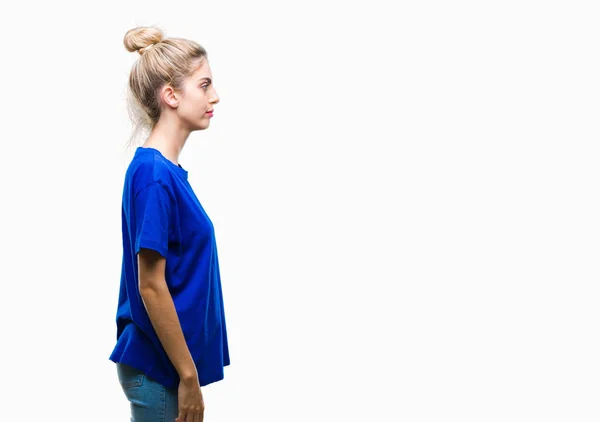 年轻美丽的金发碧眼的女人穿着蓝色的 T恤在孤立的背景寻找的一面 放松的轮廓姿势与自然的脸与自信的微笑 — 图库照片