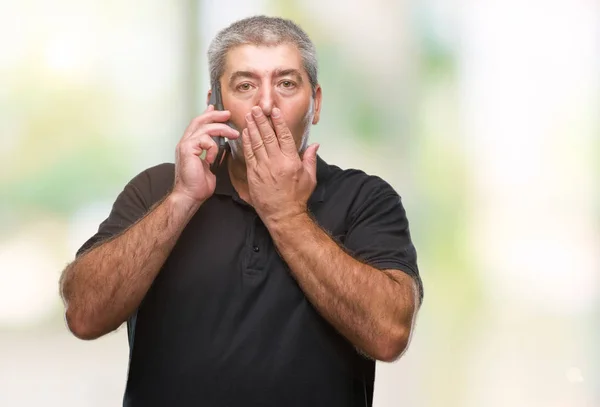 Bonito Homem Sênior Falando Smartphone Sobre Fundo Isolado Cobrir Boca — Fotografia de Stock