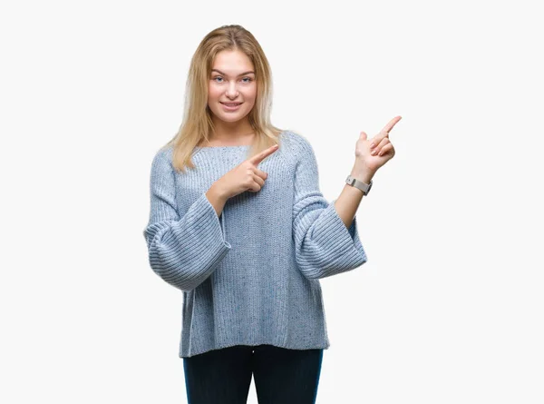 年轻的白种人妇女穿着冬季毛衣在孤立的背景微笑 看着相机指着两个手和手指到一边 — 图库照片
