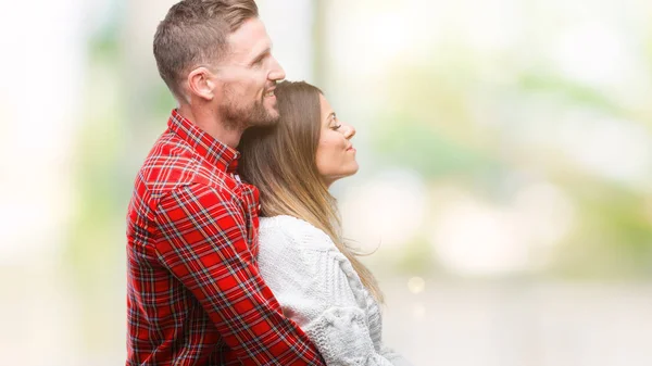 恋爱中的年轻夫妇穿着冬装毛衣越过孤立的背景 带着自信的微笑 用自然的面孔放松姿势 — 图库照片