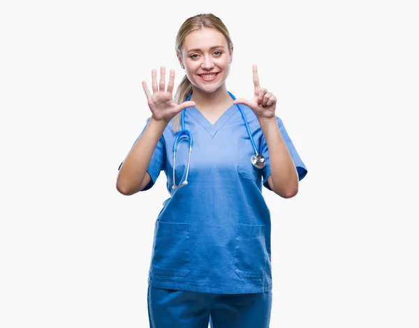 孤立した背景表示と指で上向きに若い金髪の外科医医師女性数は自信を持って 幸せな笑みを浮かべている間 — ストック写真