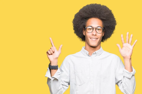 非洲青年美国男子戴着非洲头发戴眼镜 一边微笑着自信和快乐 一边用手指指着七号 — 图库照片