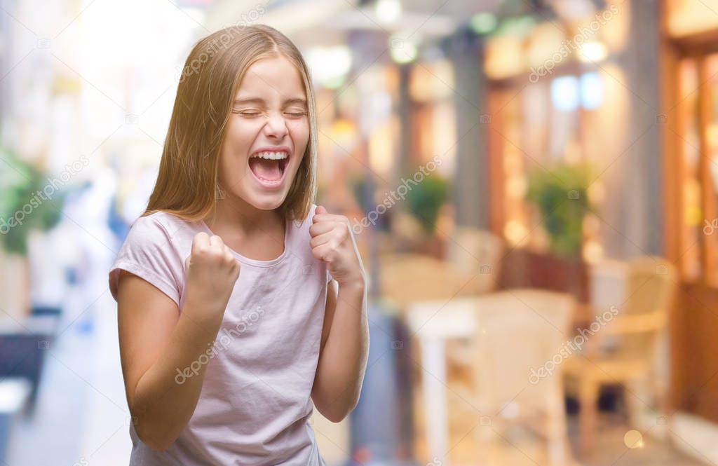 Young beautiful girl over isolated background very happy and excited doing winner gesture with arms raised, smiling and screaming for success. Celebration concept.