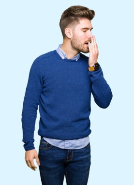 Genç yakışıklı bussines adam esneme yorgun kapsayan ağız el ile sıkılmış. Restless ve uyku hali.